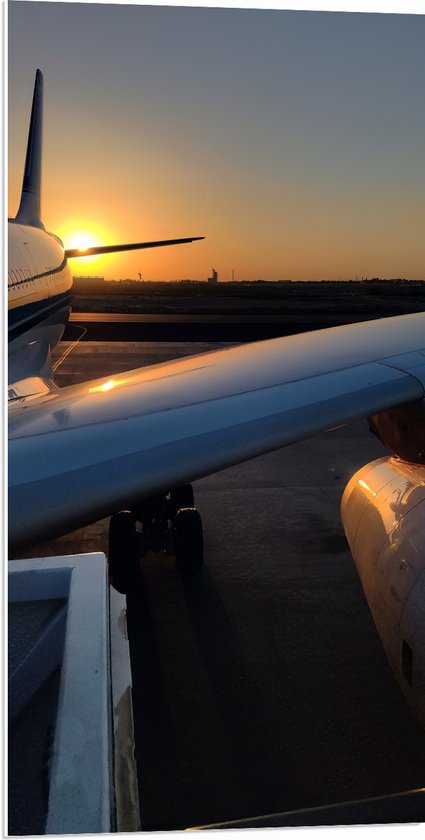 PVC Schuimplaat - Vliegtuigvleugel van Wit Vliegtuig Geparkeerd op Vliegbasis tijdens Zonsondergang - 50x100 cm Foto op PVC Schuimplaat (Met Ophangsysteem)