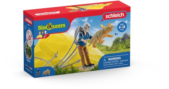 Doos speelgoed met een jonge man, triceratops en gele parachute.