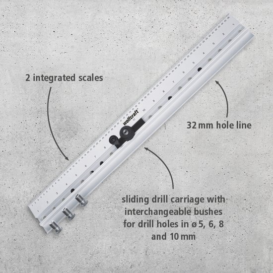 Wolfcraft deuvelmal met tekst: '2 integrated scales', '32 mm hole line' en 'sliding drill carriage'.
