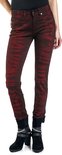 Vrouw in rode skinny jeans met zwarte batikprint, zwart shirt en zwarte laarsjes.