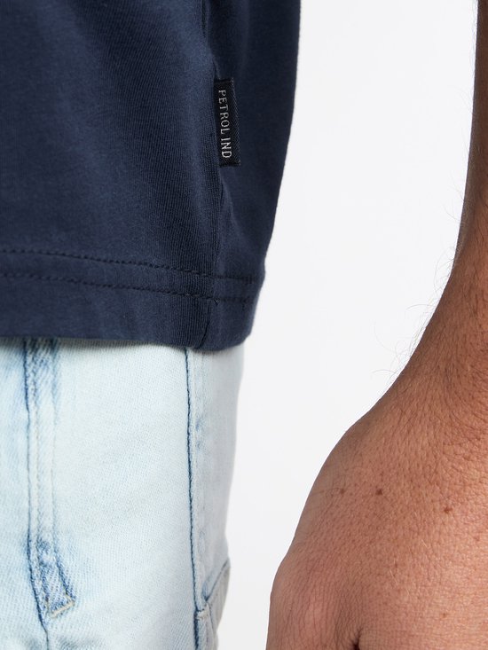 Detail van een donkerblauw T-shirt met label "Petrolind".