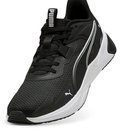 Zwarte PUMA sportschoen met witte zool en witte strepen. Getoond in een hoek, met veters.
