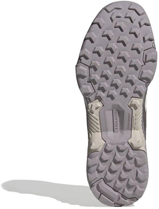 Onderkant van een grijze Adidas wandelschoen met profiel en "TRAXION" logo.