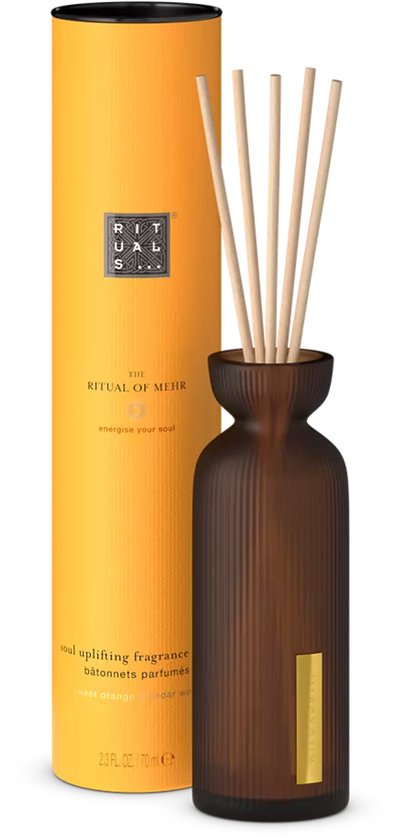 Amberkleurige diffuser met bruine geribbelde fles en vijf geur stokjes. Oranje verpakking met tekst.