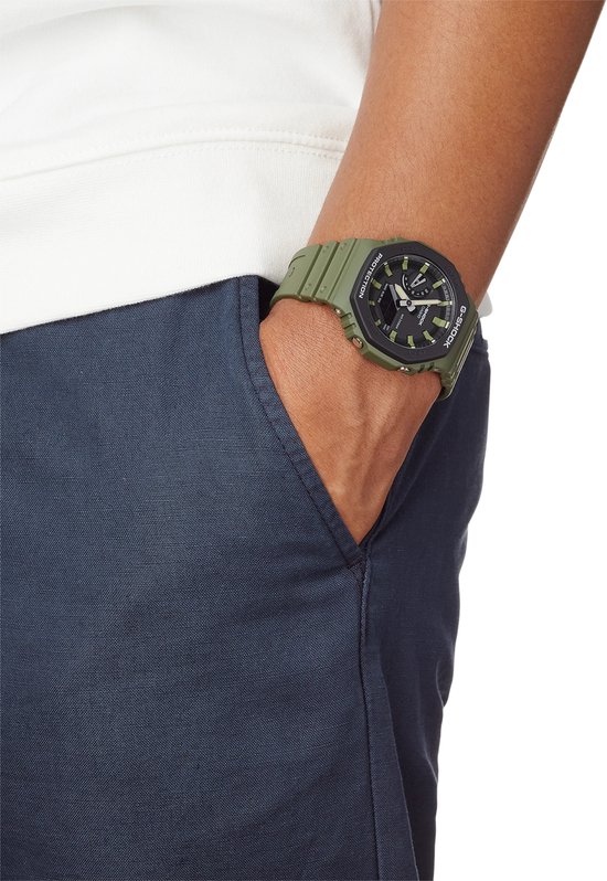 Groen G-Shock horloge met zwarte wijzerplaat op pols.