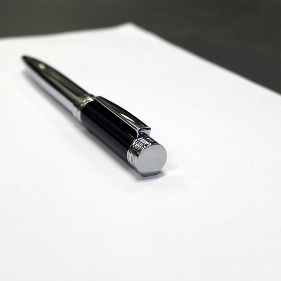 Zwarte pen met zilverkleurige clip en details, liggend op wit papier.
