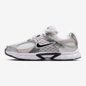 Zijprofiel van een witte Nike sneaker met zilveren en grijze overlays en een zwarte swoosh.