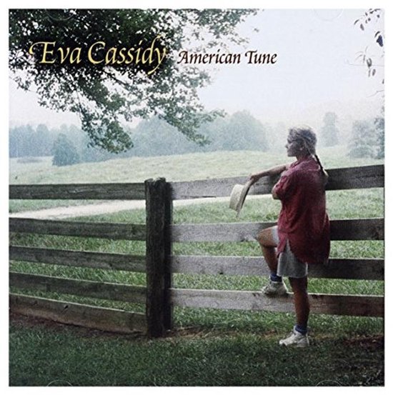 Eva Cassidy, American Tune albumhoes met een jonge vrouw die op een omheining leunt met een hoed.