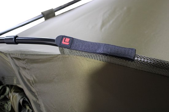 Close-up van een klittenbandsluiting met rood logo op een donkergroene tent.