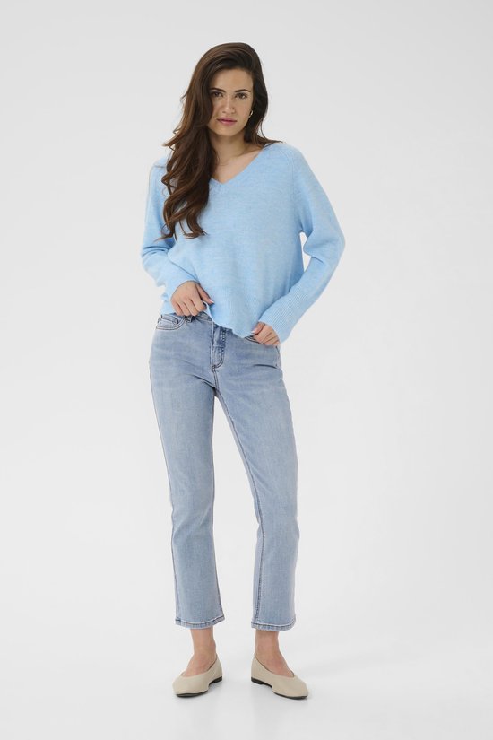 Model in een lichtblauwe melange trui met V-hals en jeans.