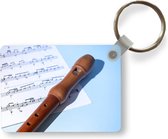 Sleutelhanger - Bruine blokfluit op bladmuziek - Uitdeelcadeautjes - Plastic