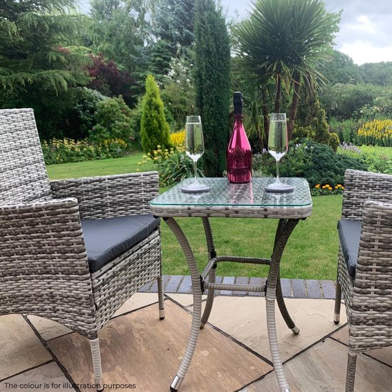 Grijze rotan stoelen en tafel in een tuinsetting, met fles en glazen.
