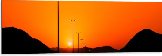 WallClassics - Dibond - Zonsondergang over Weg met Lantaarnpalen tussen Bergen - 120x40 cm Foto op Aluminium (Wanddecoratie van metaal)