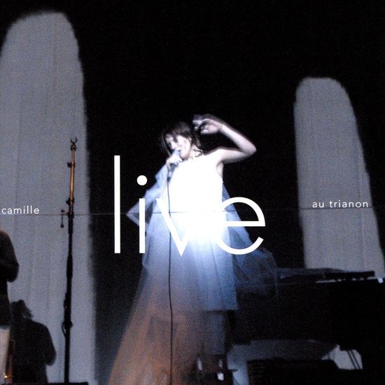 Zangeres Camille in een witte jurk op een podium voor het concert Live au Trianon.