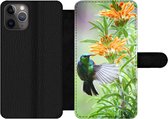 Bookcase Geschikt voor iPhone 11 Pro Max telefoonhoesje - Close-up van een kleurrijke vogel naast planten met oranje bloemen - Met vakjes - Wallet case met magneetsluiting