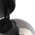 Close-up van een zwarte plafondlamp spot met een getint glazen bol.