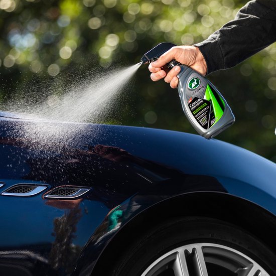 L'eau coule du capot d'une voiture foncée avec des phares.