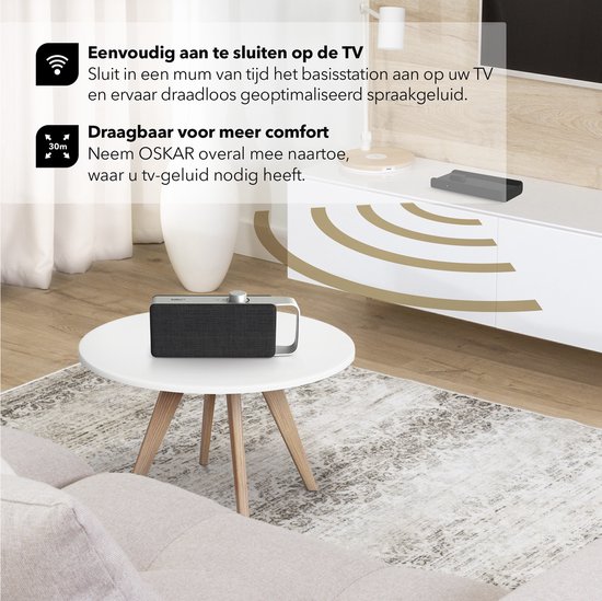 Zwarte luidspreker met zilveren handgreep op een witte salontafel in een woonkamer. Tekst: "Eenvoudig aan te sluiten op de TV" en "Draagbaar voor meer comfort".