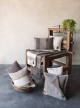 Een houten frame met diverse gebreide kussens in bruin, beige en grijstinten.