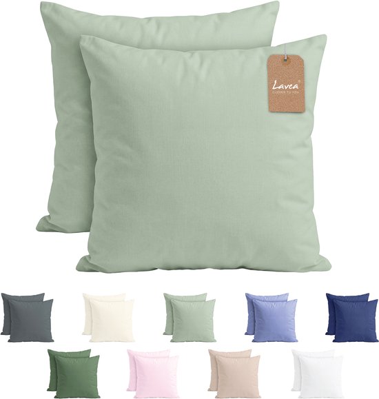 Deux oreillers vert clair avec étiquette Lavea, surmontant une rangée d'oreillers de différentes couleurs.