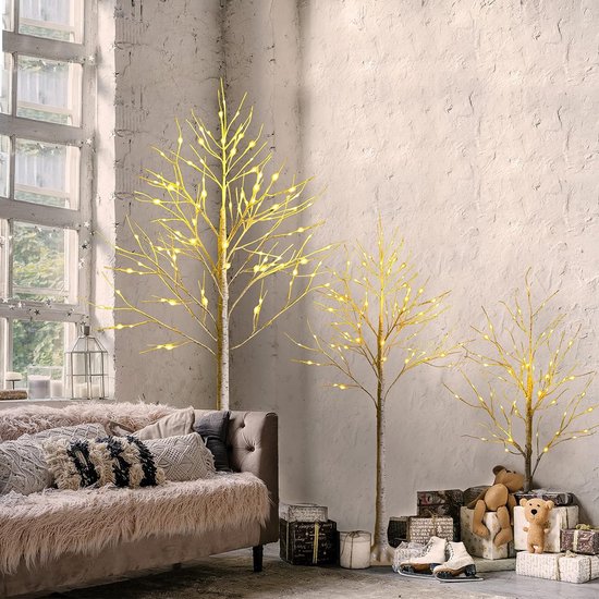 Drie verlichte kunstmatige berkenbomen met warm witte LED-lampjes in een gezellige woonkamer.
