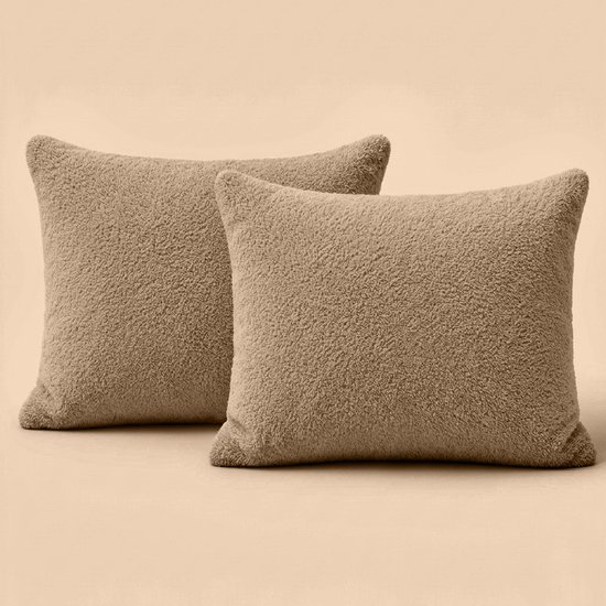 Twee taupe teddy kussens op een egale achtergrond.