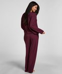 Model van achteren gezien in een paarse pyjamaset met lange mouwen.