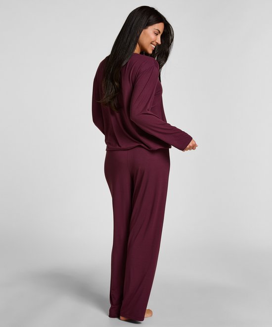 Model van achteren gezien in een paarse pyjamaset met lange mouwen.