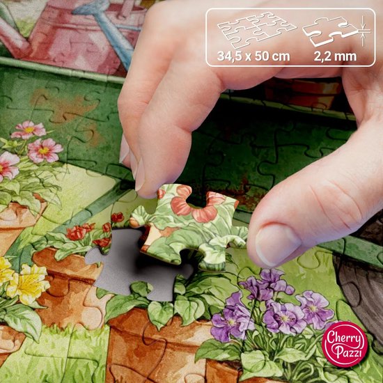 Een hand die een stuk van een 300-delige puzzel vasthoudt, met bloemen en bladeren erop afgebeeld.