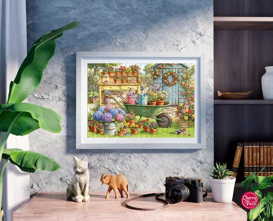 Een ingelijste 300-delige puzzel van een bloementuin met een schuur, kruiwagen en hond, hangend aan een muur boven een dressoir.