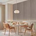 Eikenhouten lattenwandpanelen in een eetkamer met een ronde tafel en stoelen.