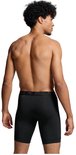 Man met donkere huid, zwart krullend haar, draagt een zwarte PUMA boxershort met lange pijpen.