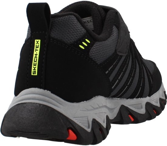 Achterkant zwarte lage sneaker met tekst "SKECH-TEX" en rode details op de zool.