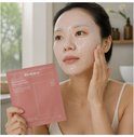 Vrouw met het Biodance Bio-Collagen Real Deep Mask op het gezicht, houdt de verpakking vast.