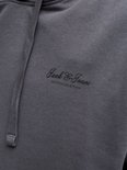 Close-up van donkergrijze hoodie met geborduurd 'Jack & Jones' logo en trekkoord.