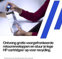 Handen stoppen een HP-cartridge in een gratis retourenvelop voor recycling.