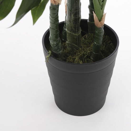 De groene stammen van een kunstplant in een zwarte pot, gevuld met mos.