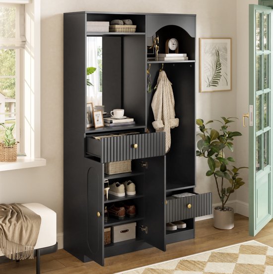 Zwart halmeubel met spiegel, open lades, schoenenkast en zitbank. Met decoratie, kleding en plant.