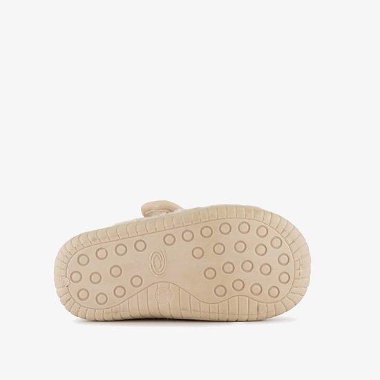 Onderkant van beige, teddy slof met ronde nopjesprofiel op de rubberen zool.