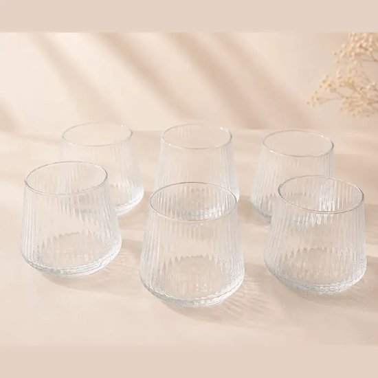 Ensemble de six verres vides aux cannelures verticales et à la forme effilée.