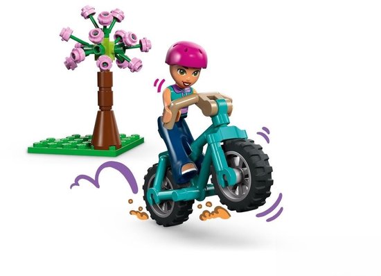 Meisje met roze helm op turquoise fiets met grote wielen en grote wielen