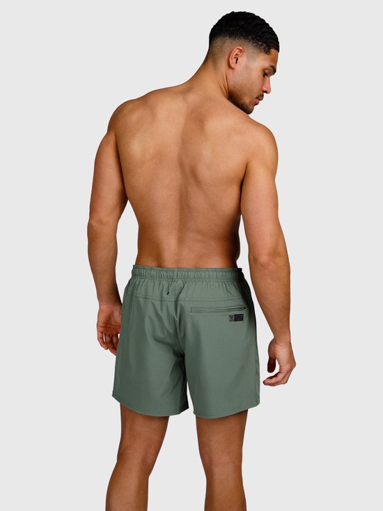 Homme vu de dos, portant un short de bain vert vintage avec une poche zippée au dos.