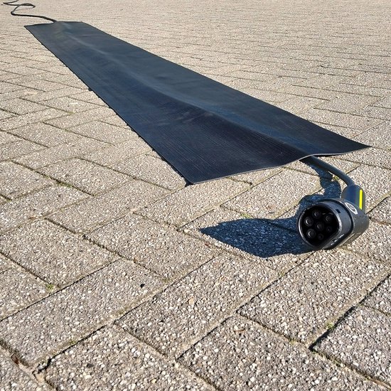 Zwarte, flexibele kabelmat met ribbelpatroon en een laadstekker op een betegelde ondergrond.