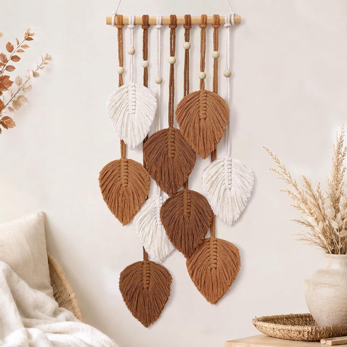 Geweven wandkleed in boho-stijl met bladmotief — handgemaakt van katoenen koord; voorzien van een houten roede en houten kralen; geschikt als wanddecoratie in slaapkamers, woonkamers en kinderkamers.