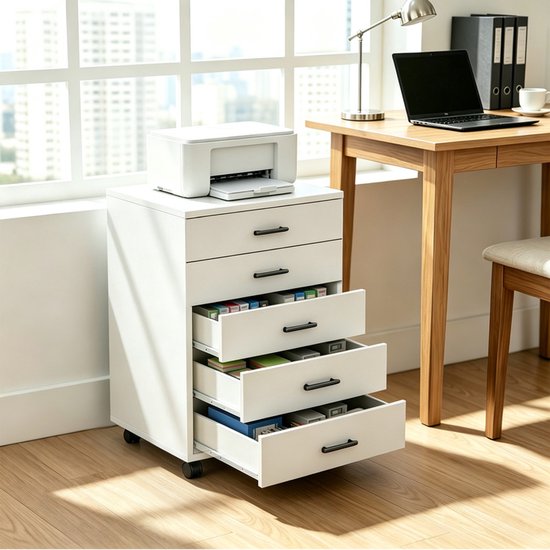 Wit 5-laags archiefkastje met open laden gevuld met diverse spullen, naast een houten bureau.