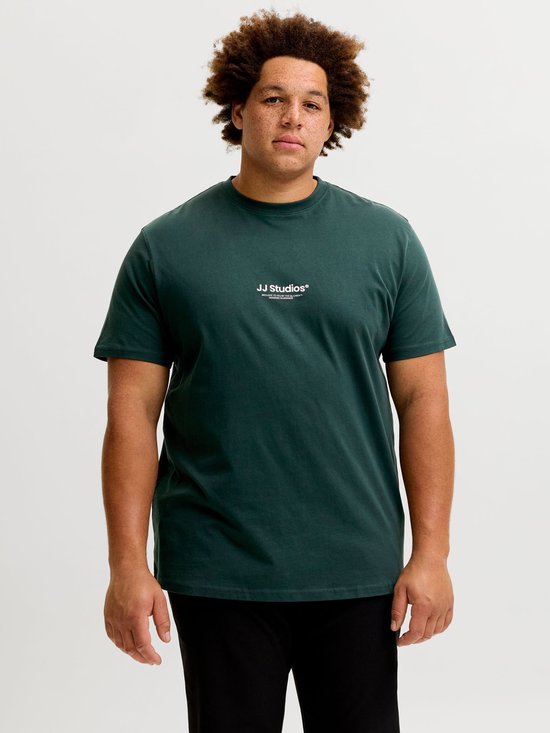 Man met krullend haar, gekleed in een donkergroen T-shirt met witte 'JJ Studios' tekst op de borst.