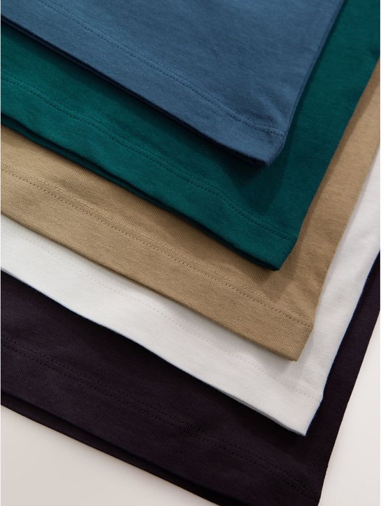 Close-up van de onderkant van vijf gestapelde T-shirts in blauw, groen, beige, wit en donkergrijs.