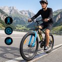 Zwarte TIGER MTB-fiets met blauwe voorvork, 26-inch wielen en derailleur, bereden door een man in de bergen.