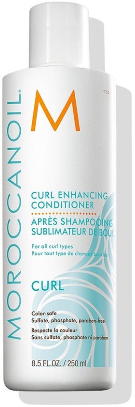 Witte fles Moroccanoil "Curl Enhancing Conditioner" met golvend blauw patroon op de achtergrond.