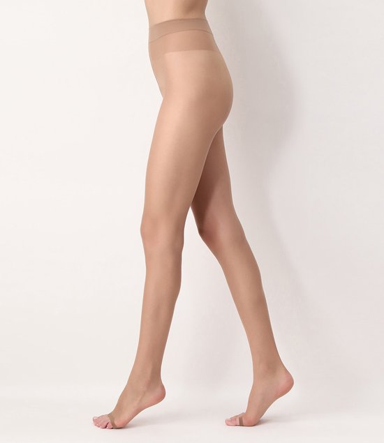 Een vrouw met blote benen in een huidskleurige panty, van opzij gezien.